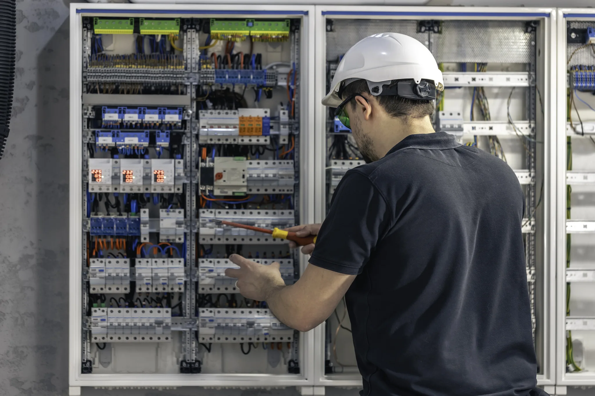 male electrician works switchboard using electrical connection cable 1 jpg
